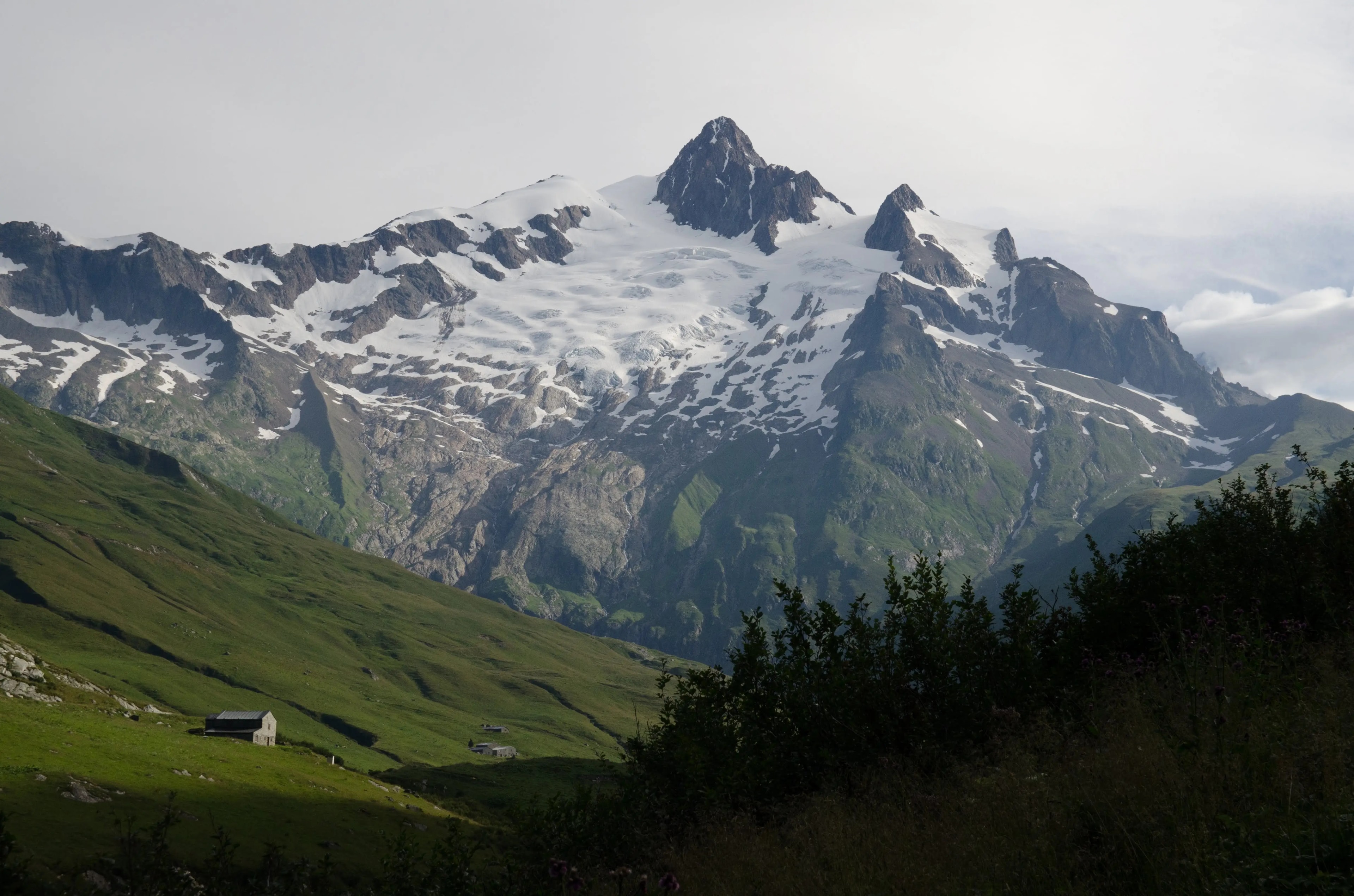 Panoramic alpine view of green valleys and snow-capped peaks along the TMB Panoramic alpine view of green valleys and snow-capped peaks along the TMB
